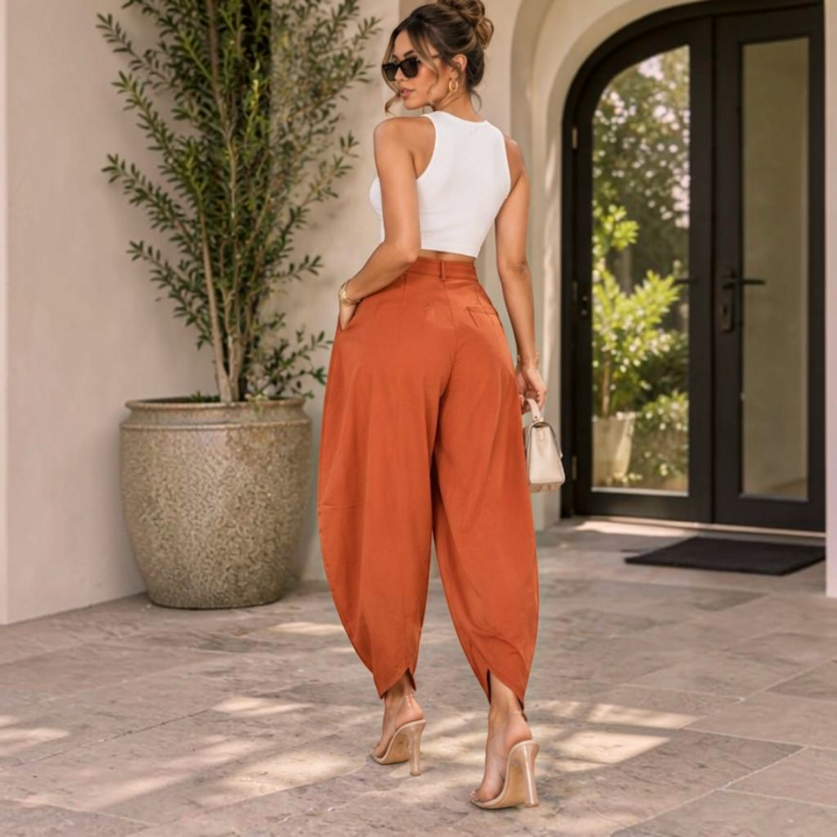 Angie Style Boutique rust orange high-waisted balloon pants with back pleats and pockets, worn with a white crop top.