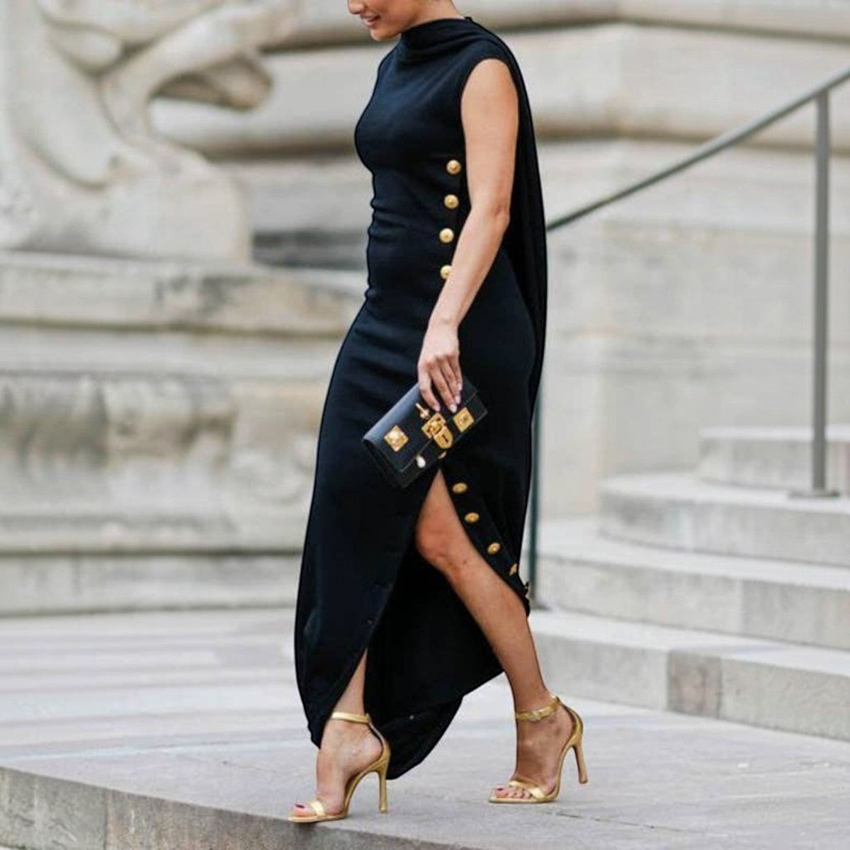 Angie Style Boutique black sleeveless maxi dress with shawl collar, side buttons, and split-side detail on a model.