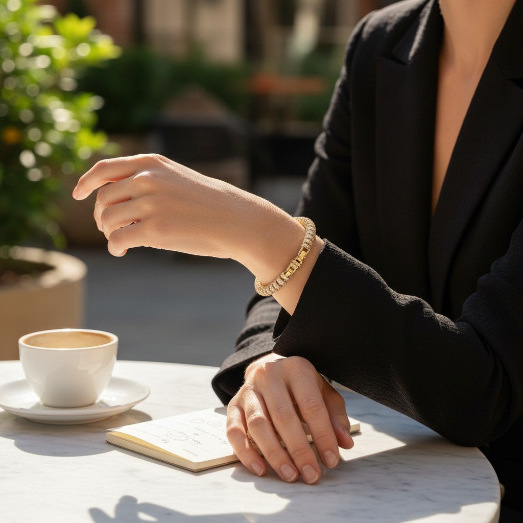 Angie Style Boutique gold chunky chain link bracelet worn by a woman in a black blazer at an outdoor cafe table.