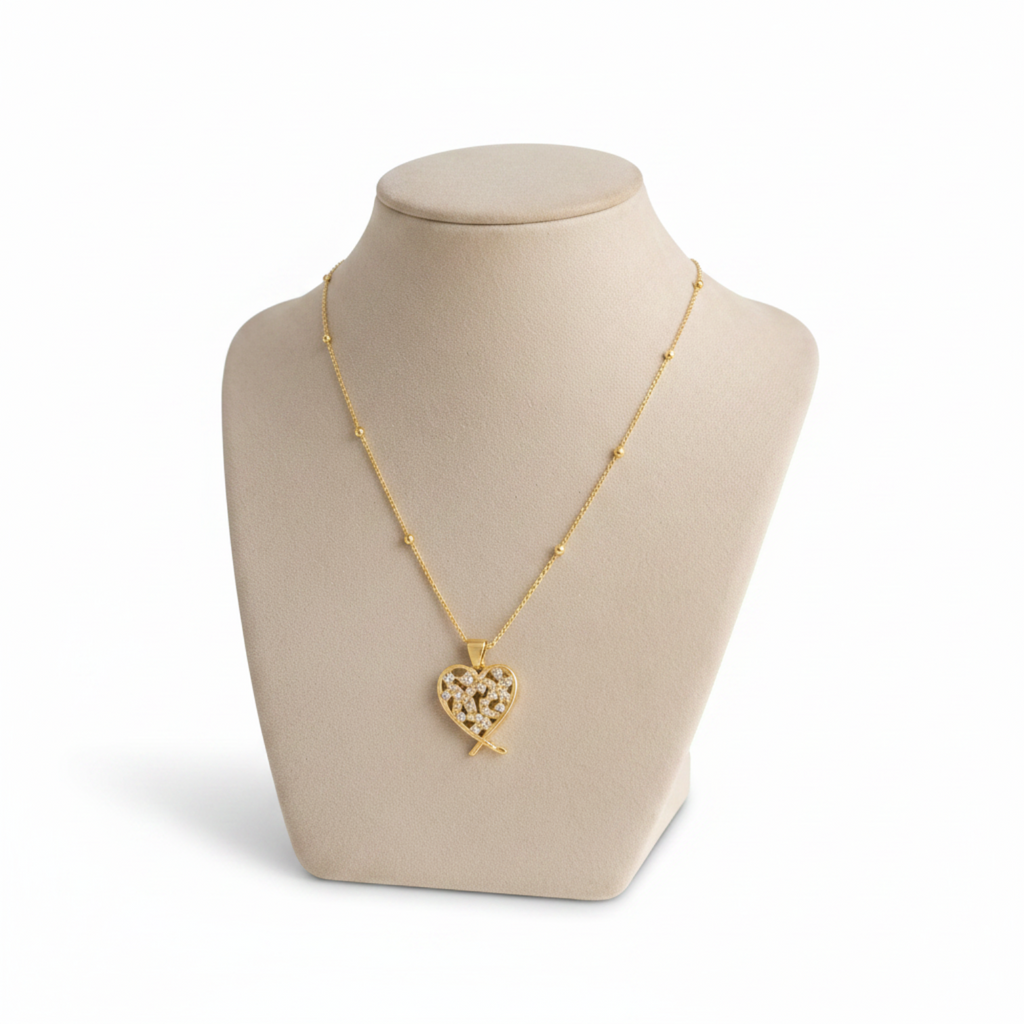 Angie Style Boutique gold heart pendant necklace with pavé cubic zirconia stones on a beige jewelry display bust