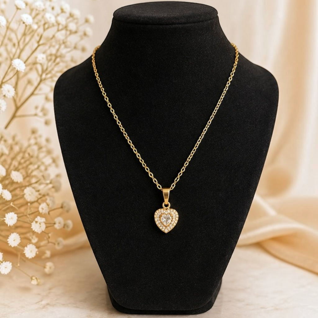 Angie Style Boutique gold heart pendant necklace with sparkling cubic zirconia stones on a black jewelry display bust